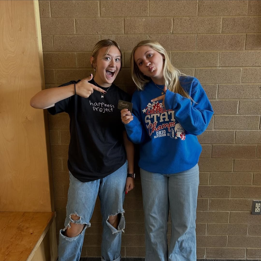Natalie Laymon and Chloe Reynolds holding up a gift card they won from the Streaks in the Stands raffle.